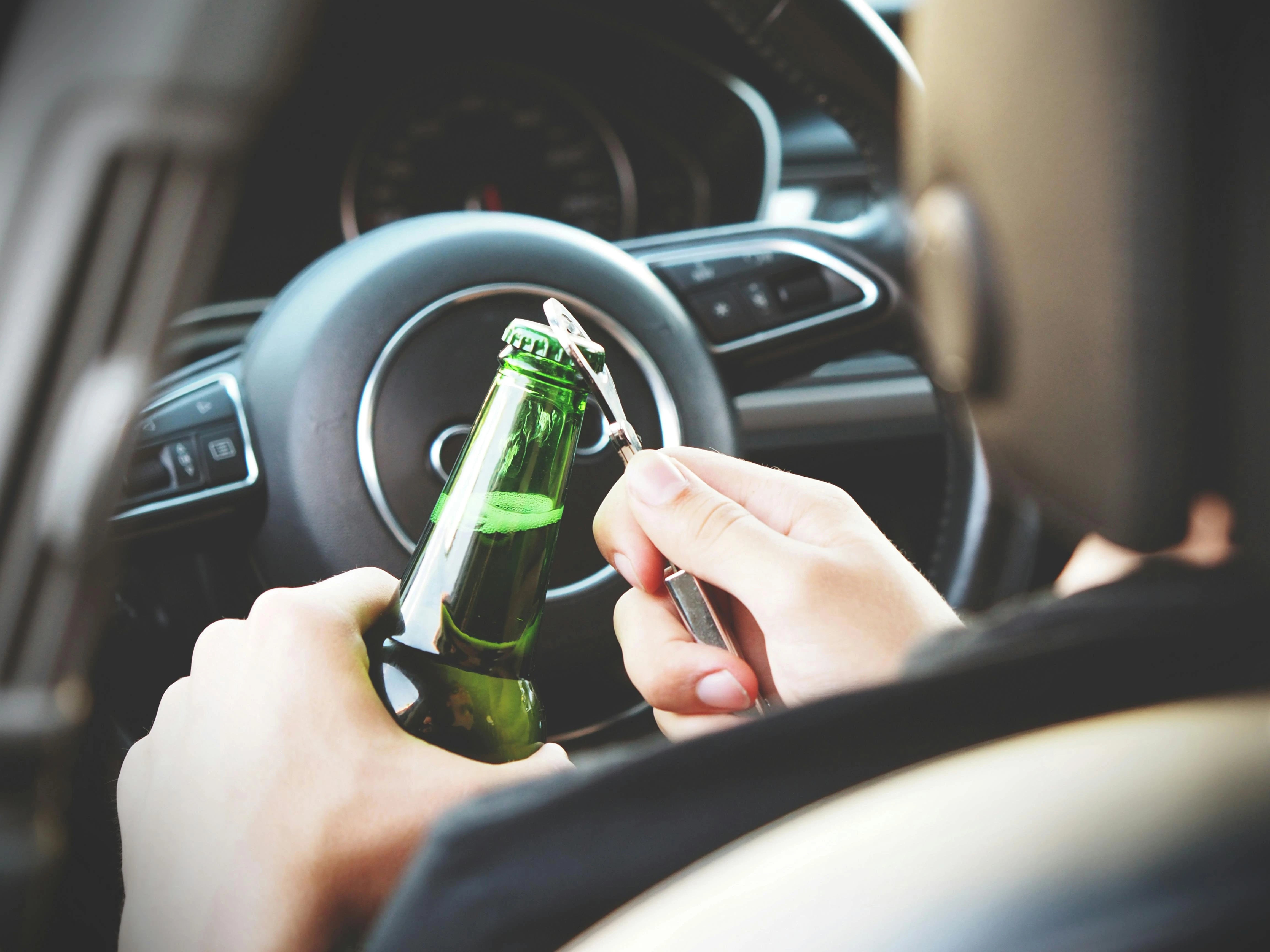 man holding bottle while driving
